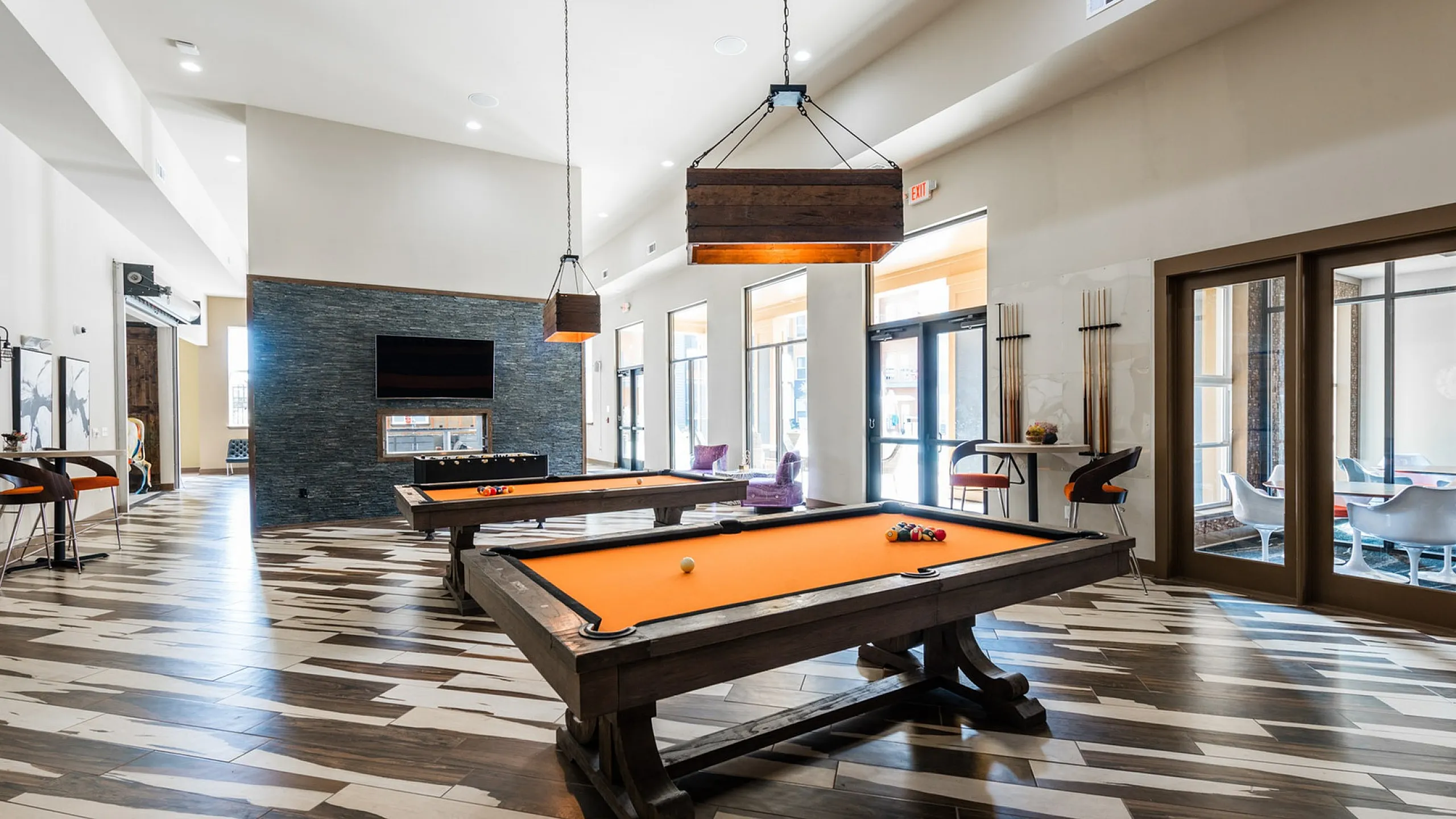 Luxurious game room with stylish pool tables and modern lounge seating, perfect for relaxation and entertainment.