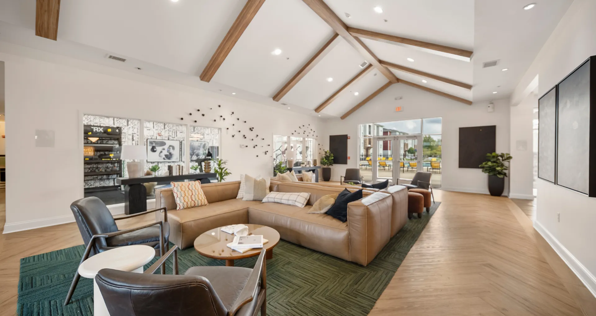 Inviting living area with vaulted ceilings and elegant wooden beams, featuring plush seating and stylish d&eacute;cor for a cozy atmosphere.