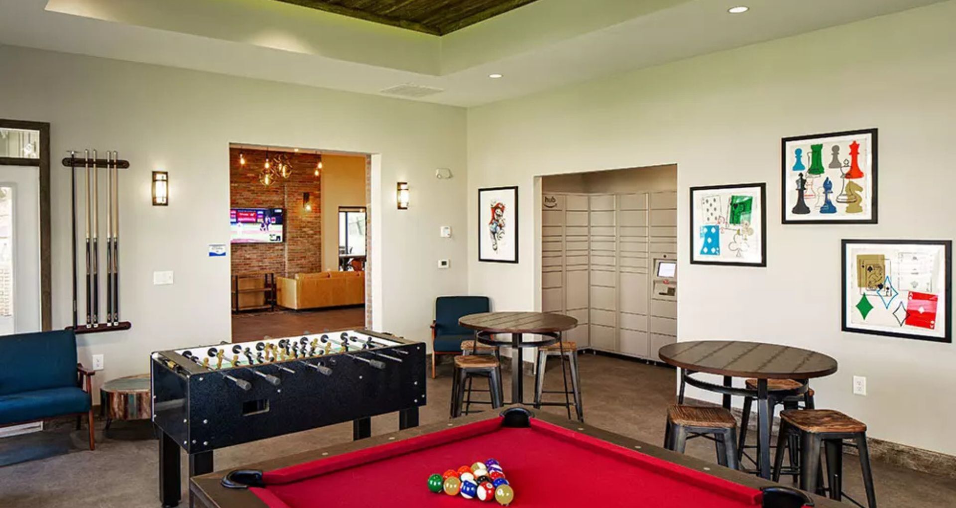 Inviting game room featuring a vibrant red pool table, foosball, and modern artwork, perfect for entertainment and relaxation.