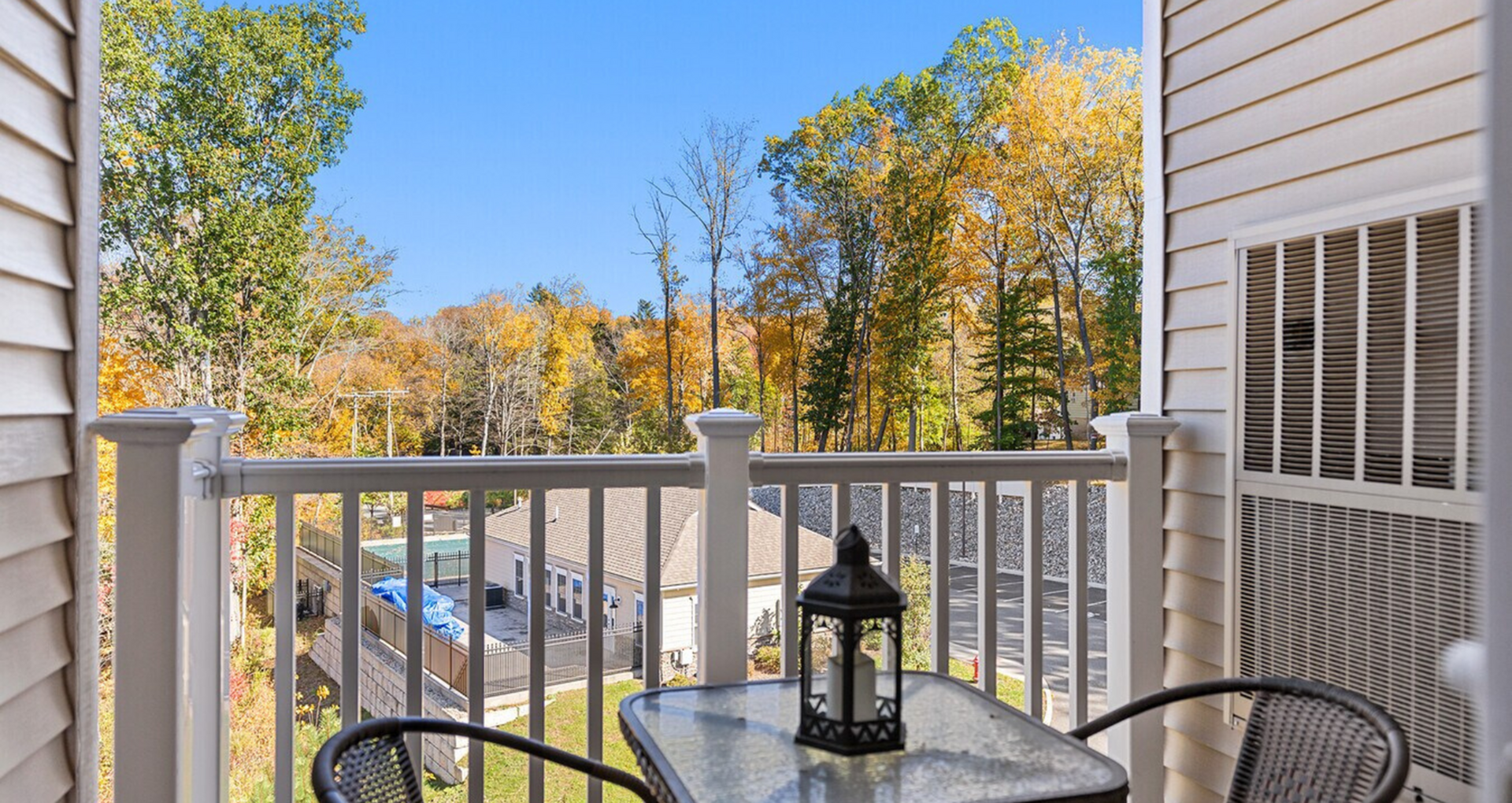 Charming apartment balcony overlooking vibrant autumn trees, offering a peaceful and scenic view, perfect for relaxation.