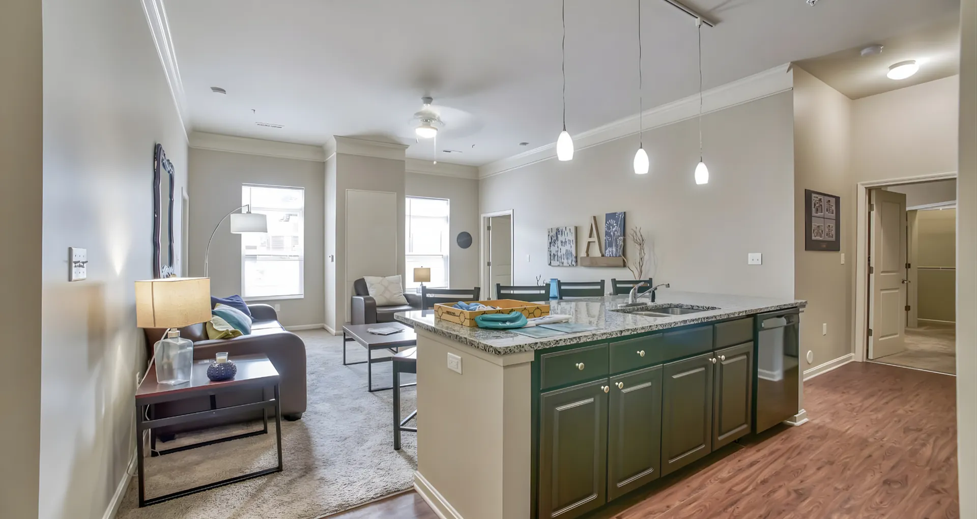 Modern open-concept living space featuring a stylish kitchen with granite countertops and a cozy seating area with abundant natural light.