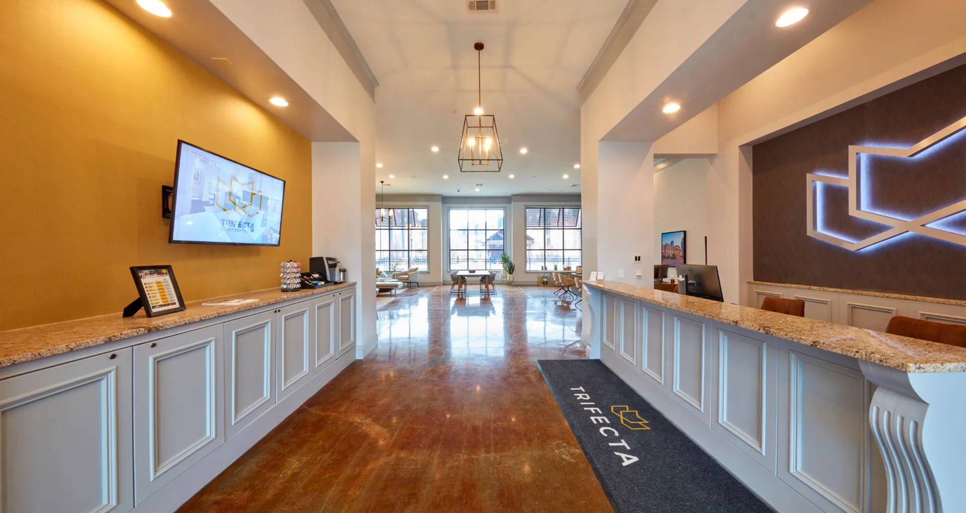 Elegant apartment lobby with polished floors, modern reception desk, and large windows offering ample natural light.