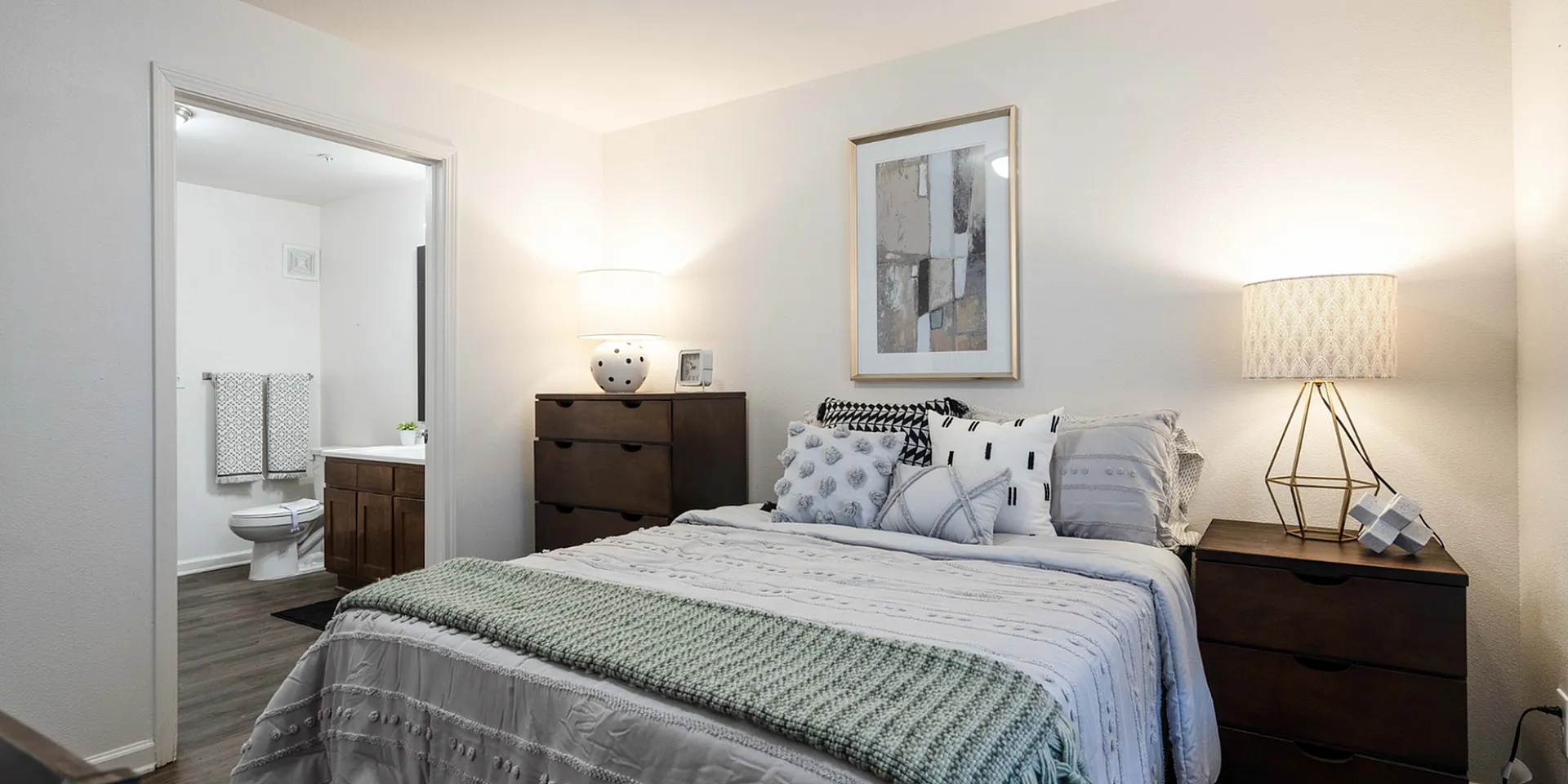Cozy bedroom with elegant decor, soft lighting, and an en-suite bathroom, perfect for relaxation and comfort.