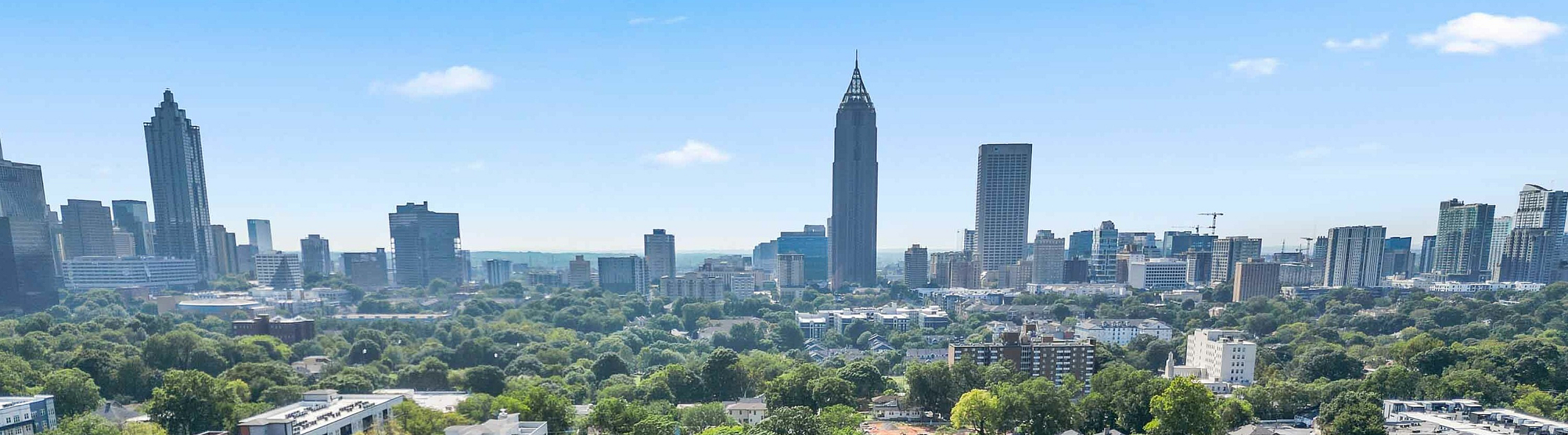 Breathtaking aerial view of a vibrant urban landscape, showcasing modern apartment buildings amidst lush greenery with a striking city skyline in the background.
