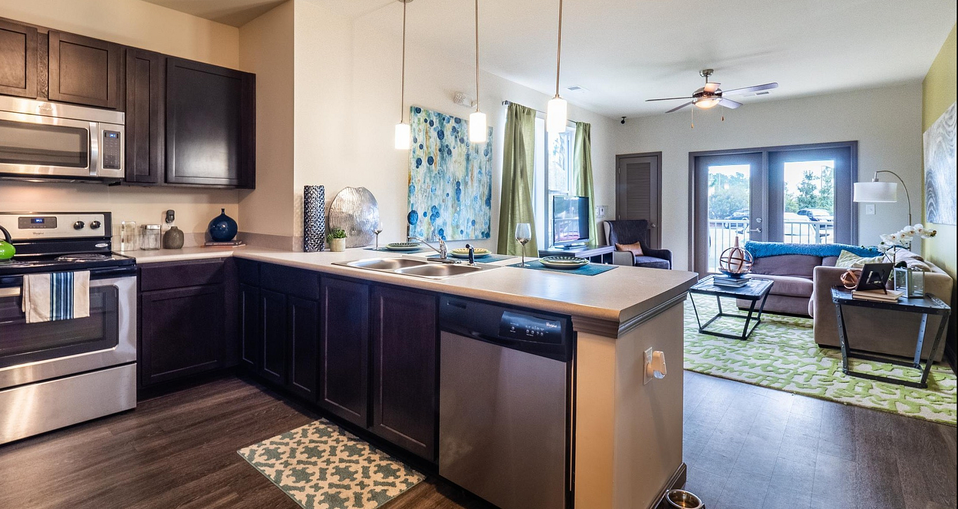 Contemporary open-concept apartment with sleek kitchen and inviting living area, featuring modern appliances and abundant natural light.