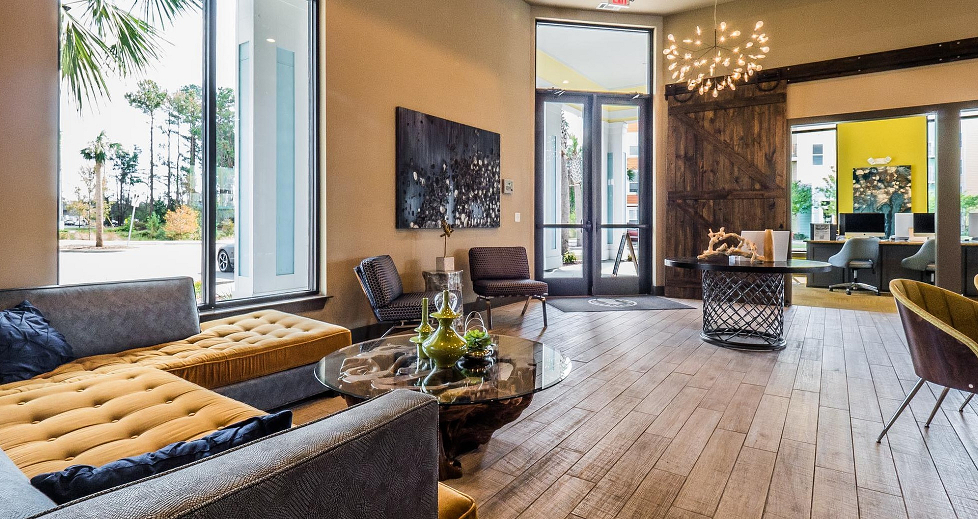 Luxurious apartment lounge featuring modern decor with cozy seating, natural light, and elegant chandeliers.