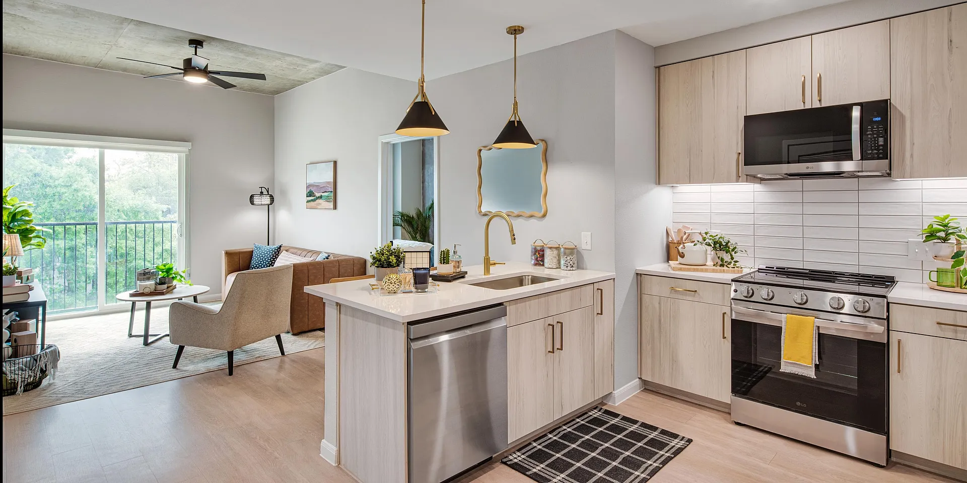 Inviting open-concept living space featuring a modern kitchen with stainless steel appliances, cozy lounge area, and abundant natural light.