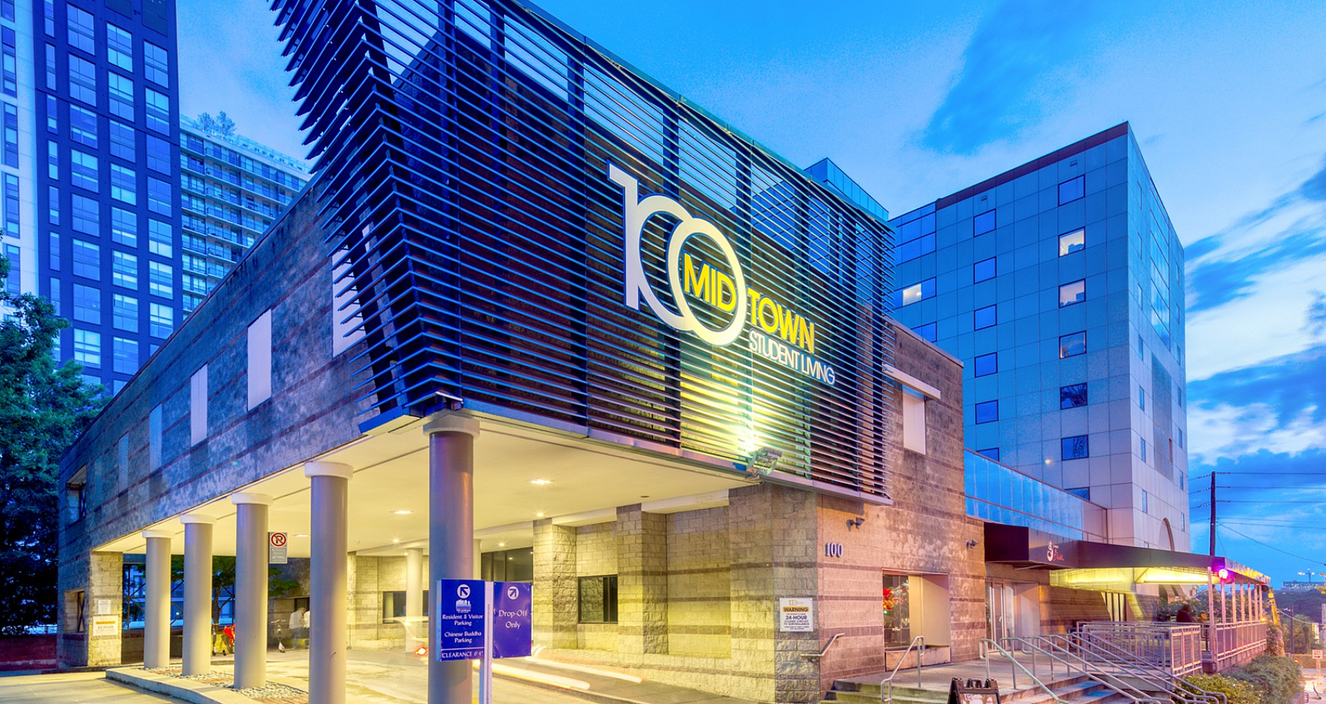 Modern student living complex at dusk showcasing contemporary architecture and vibrant city surroundings.