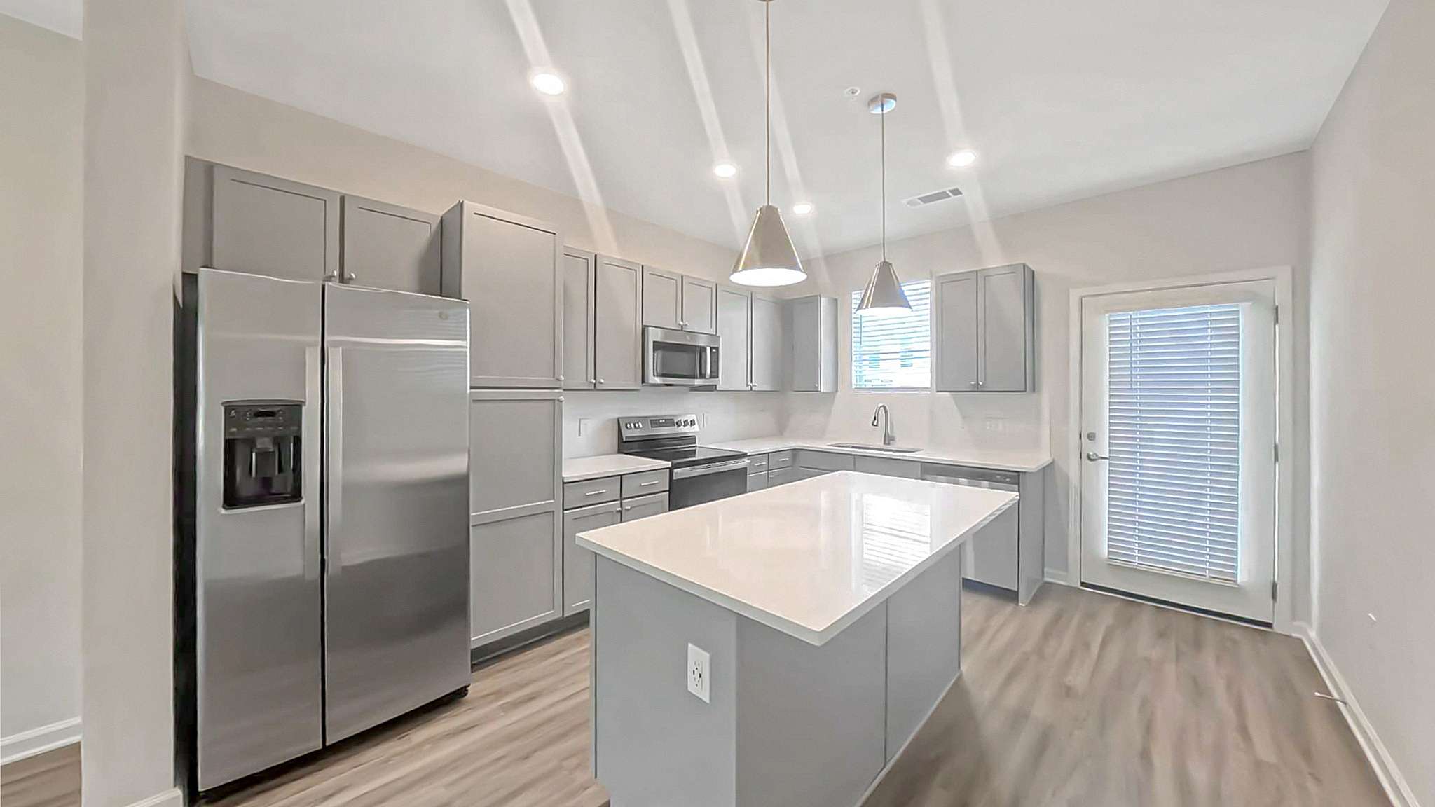Sleek modern kitchen with stainless steel appliances, elegant cabinetry, and a spacious island countertop.