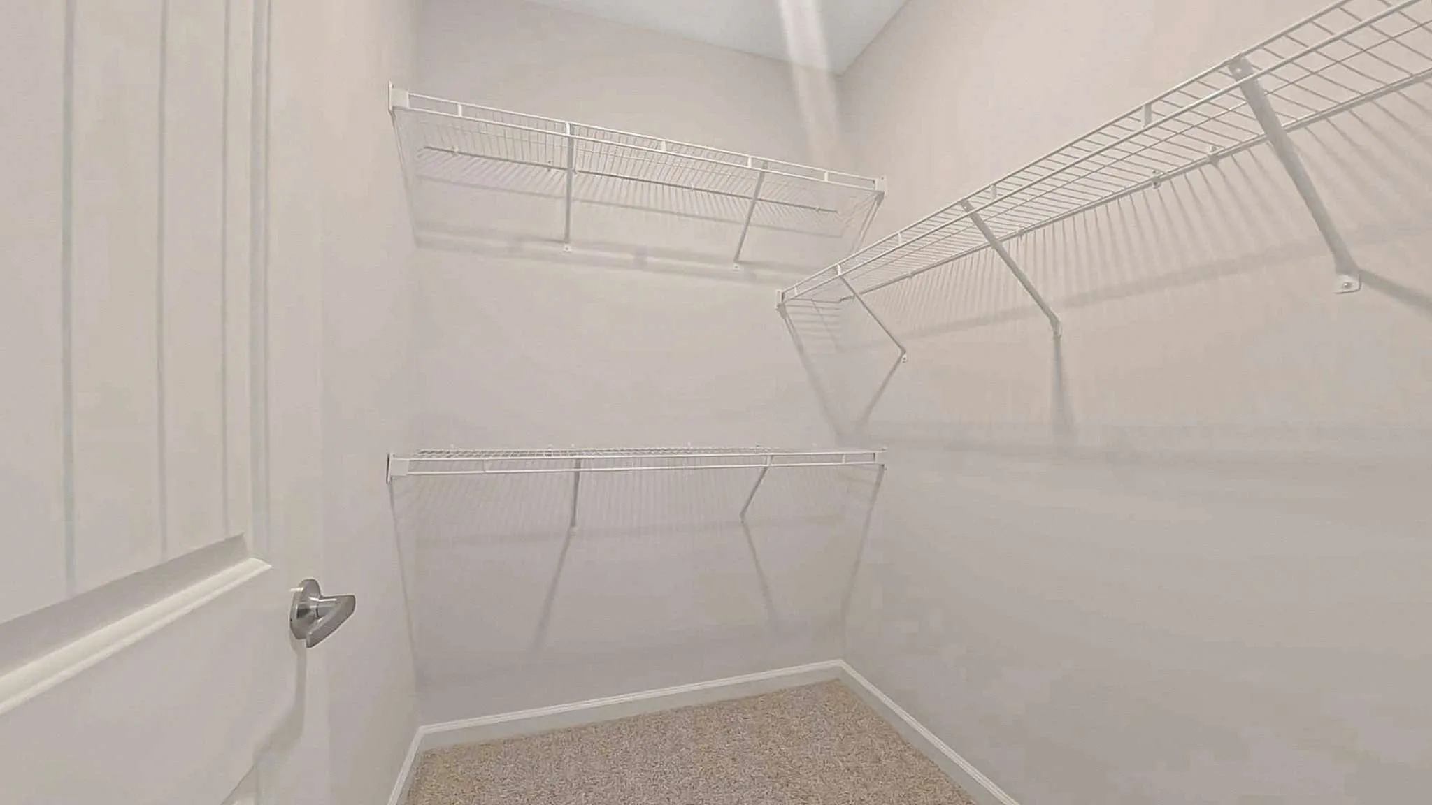Spacious walk-in closet with abundant shelving and bright lighting, perfect for organized storage.