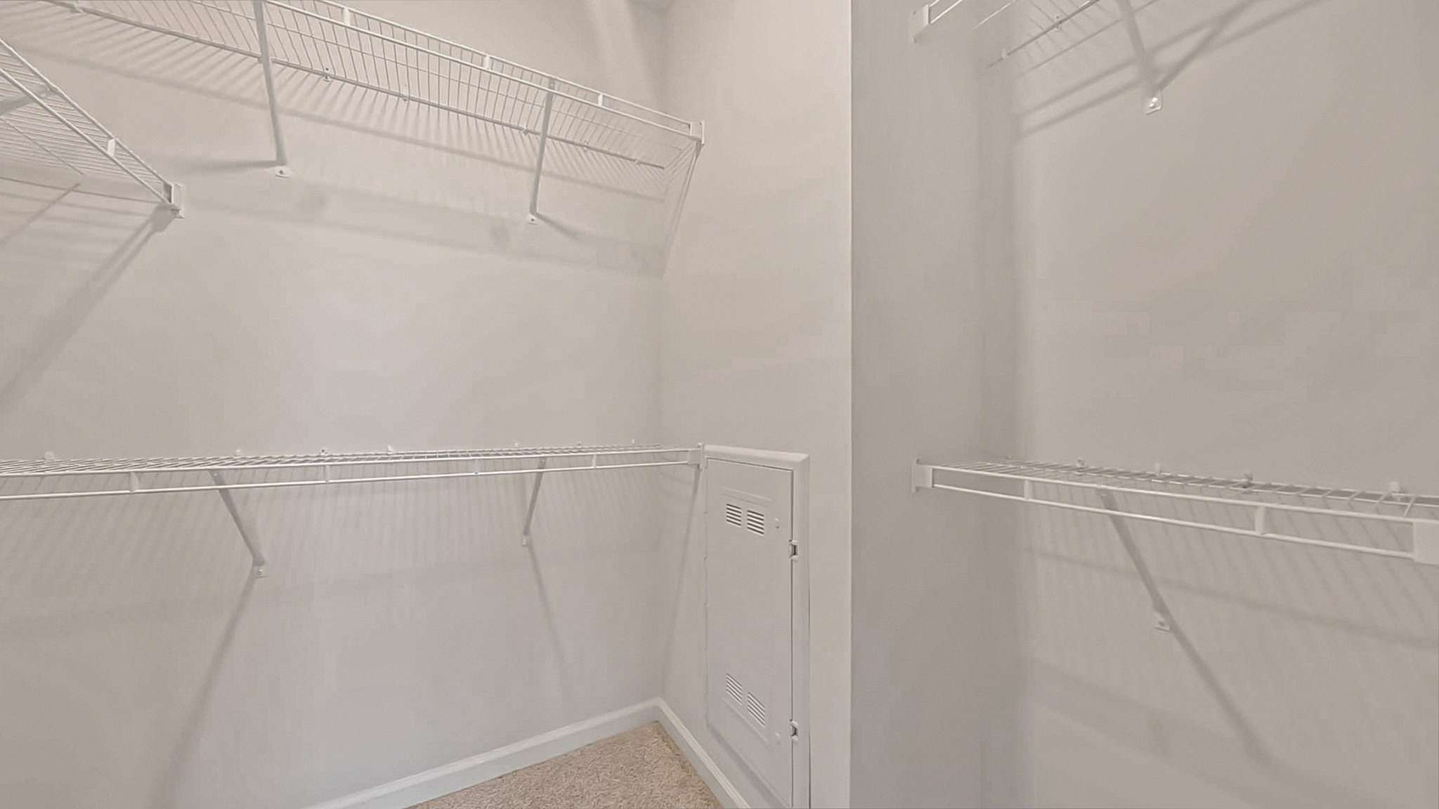 Spacious walk-in closet with wire shelving, ideal for organized storage and maximizing space.