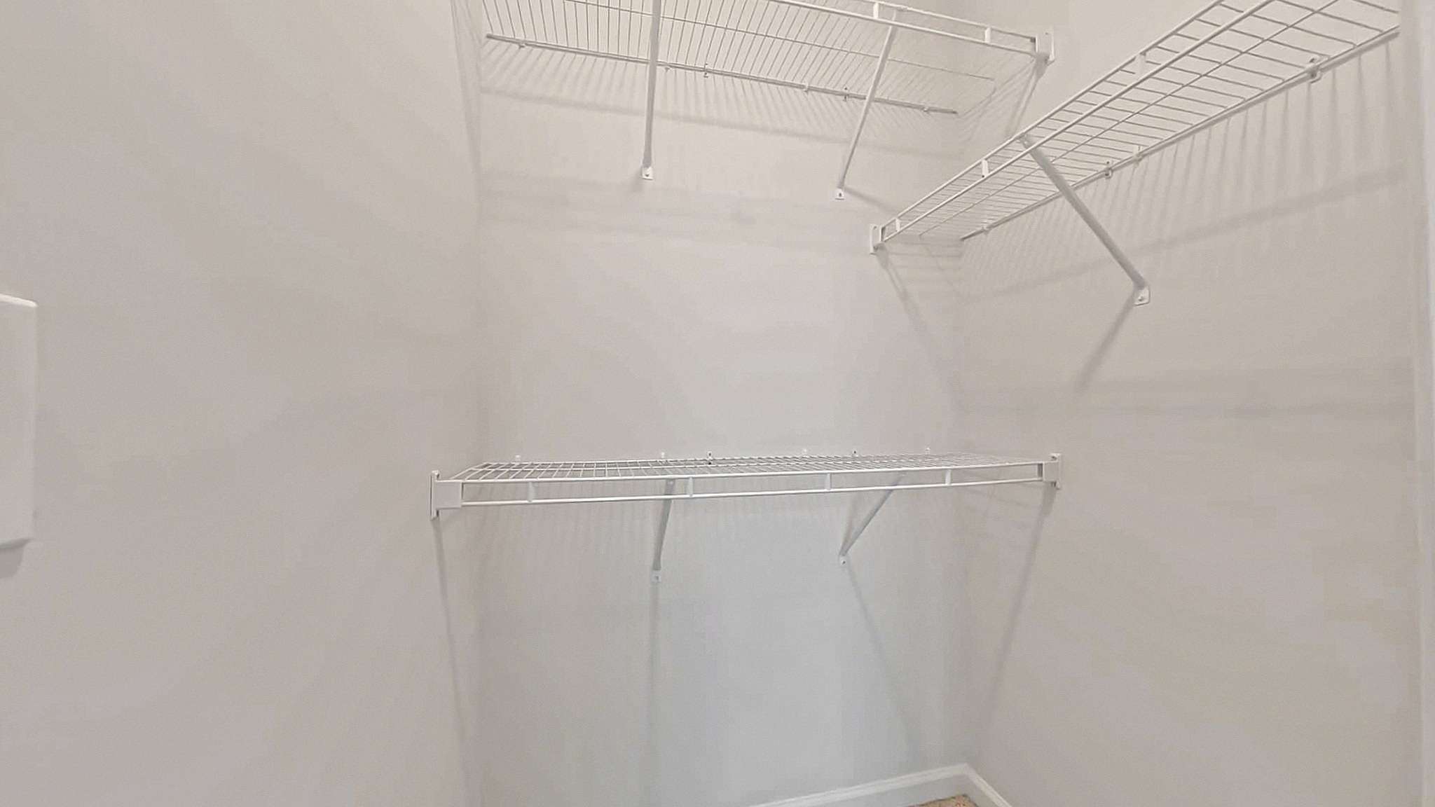 Spacious walk-in closet with sleek wire shelving, perfect for organized storage in a modern apartment.