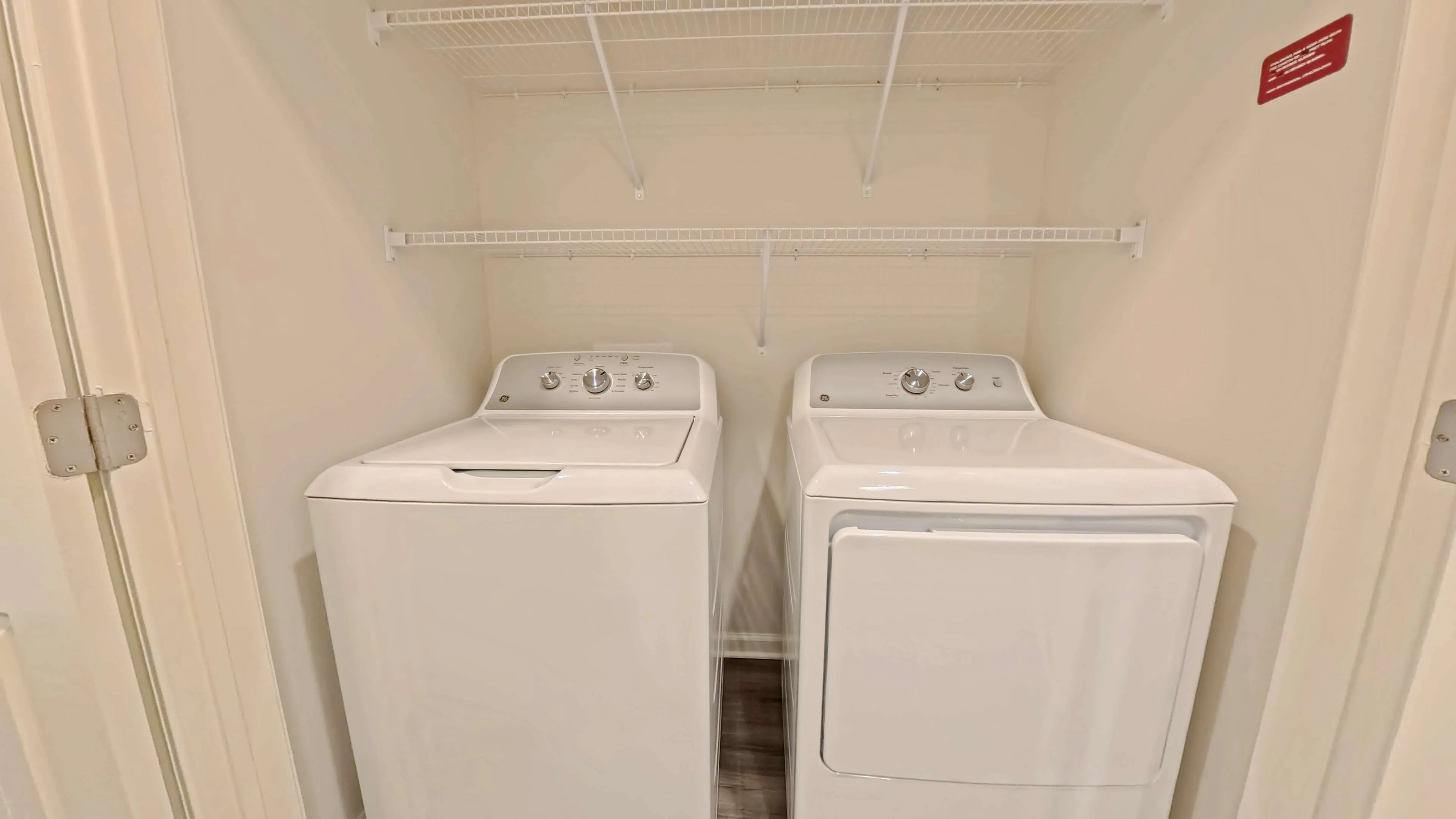 Convenient laundry area featuring a modern washer and dryer set with built-in shelving for storage.