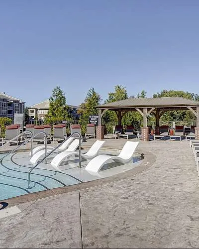 Luxurious poolside paradise featuring elegant lounge chairs and a stylish gazebo for ultimate relaxation.