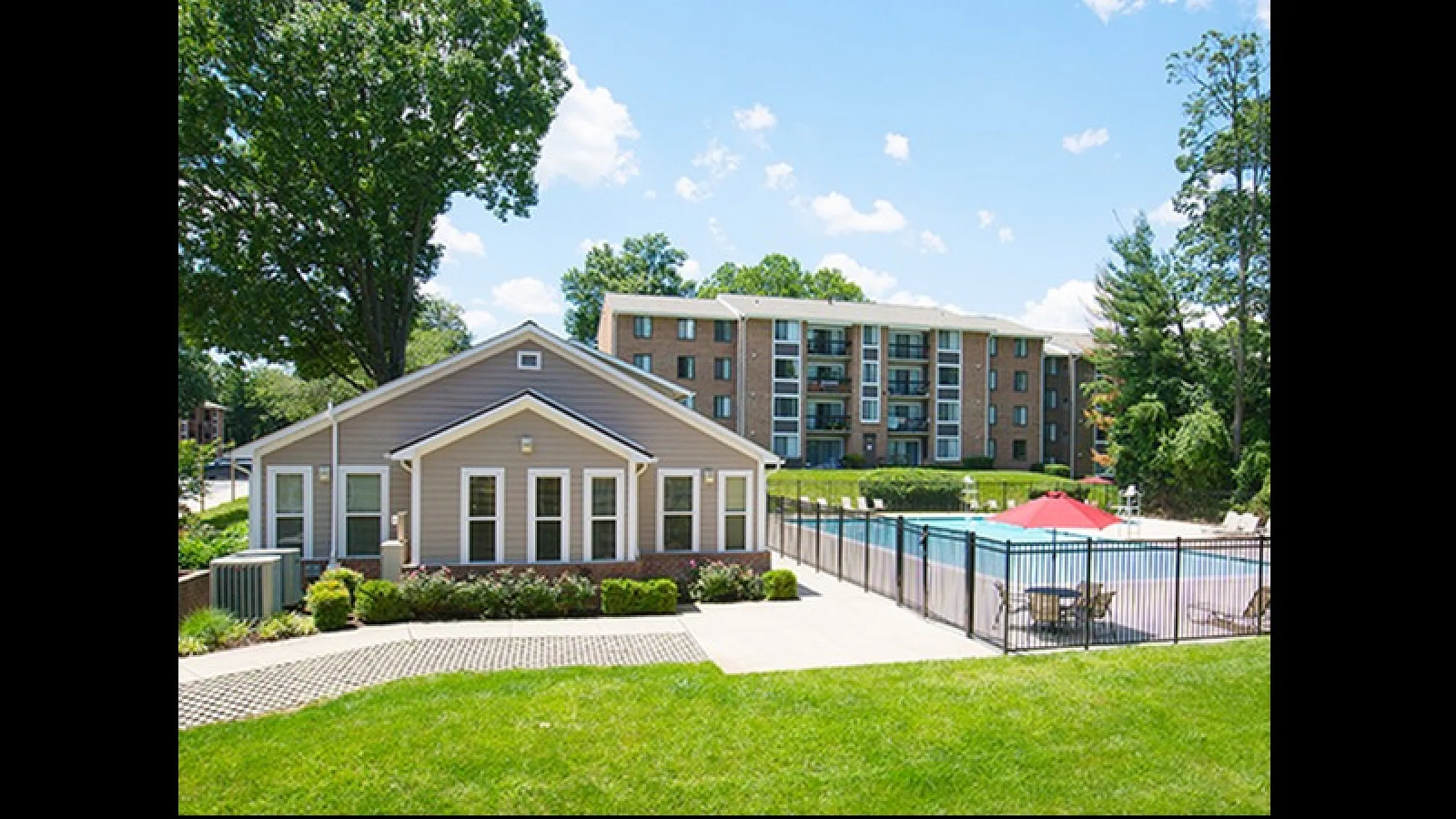 Charming apartment complex with inviting outdoor pool, surrounded by lush greenery and modern architecture.