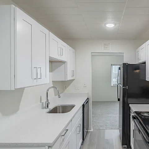 Modern kitchen with sleek white cabinetry, featuring a polished countertop and state-of-the-art appliances.