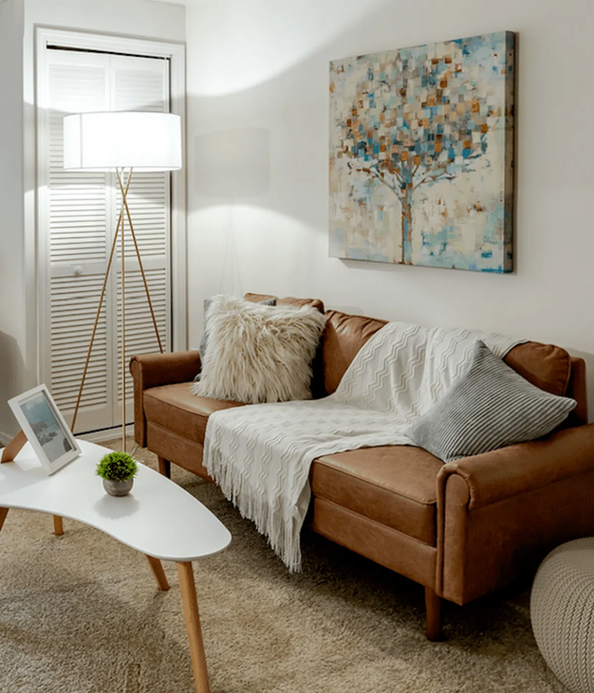 Inviting living room with a cozy brown leather sofa, elegant armchair, stylish coffee table, and chic decor, perfect for relaxing evenings.