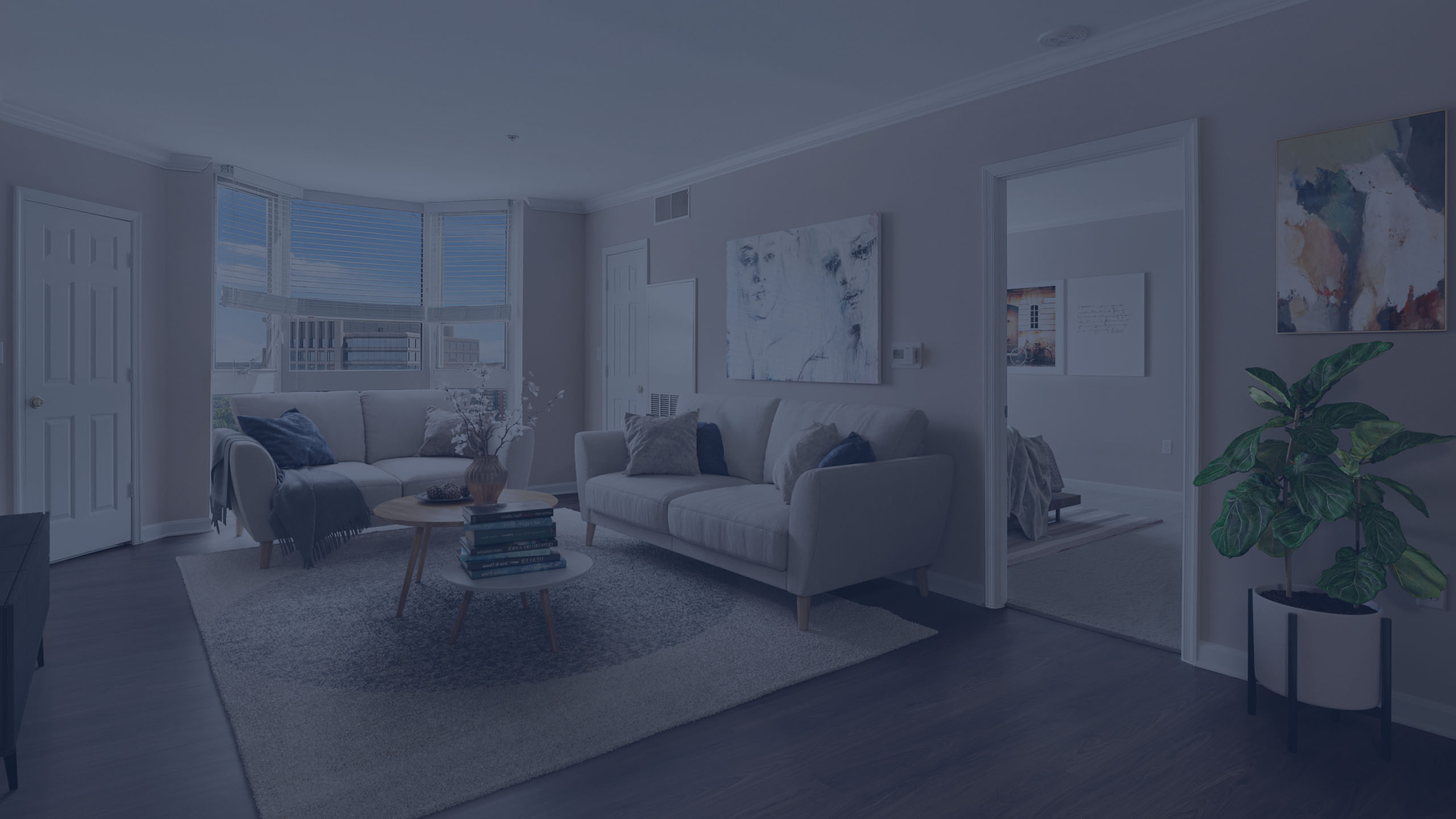 Chic living room featuring cozy sofas, a stylish round coffee table, and large windows with vibrant outdoor views.