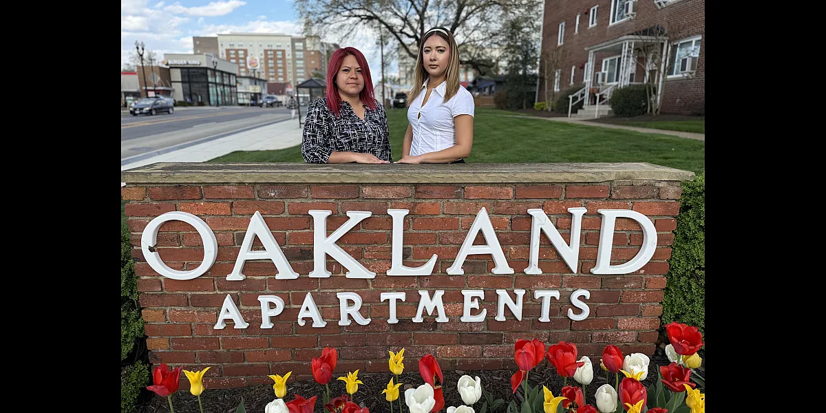 Charming Oakland Apartments entrance with vibrant tulips and manicured lawns, showcasing a welcoming community environment.