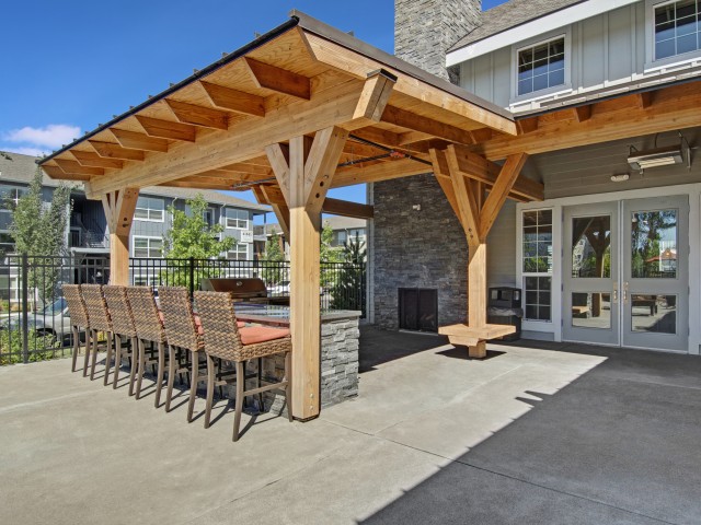 Image of Outdoor Gas BBQ and Dining Area with Park Benches for Seasons Apartments at Farmington Reserve