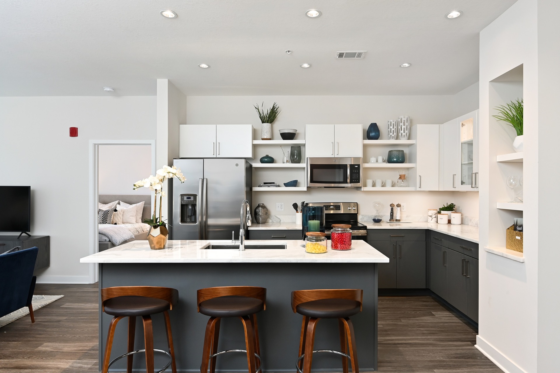 District Flats kitchen with island: A spacious and stylish kitchen in District Flats apartments featuring a central island. The island is equipped with a countertop, sink, and seating area, creating a functional and inviting space for cooki