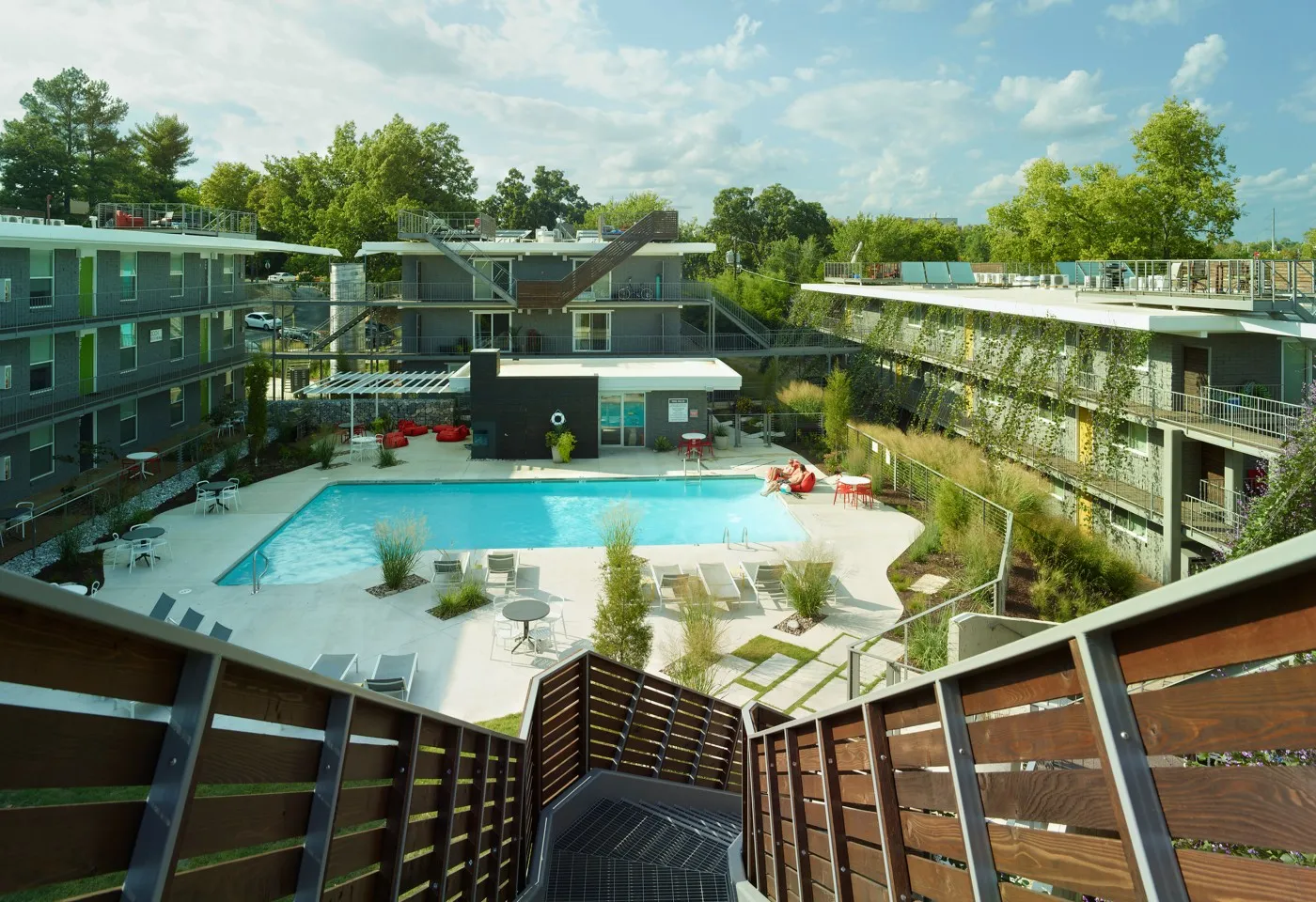 stairway descends from a roof deck to a pool courtyard