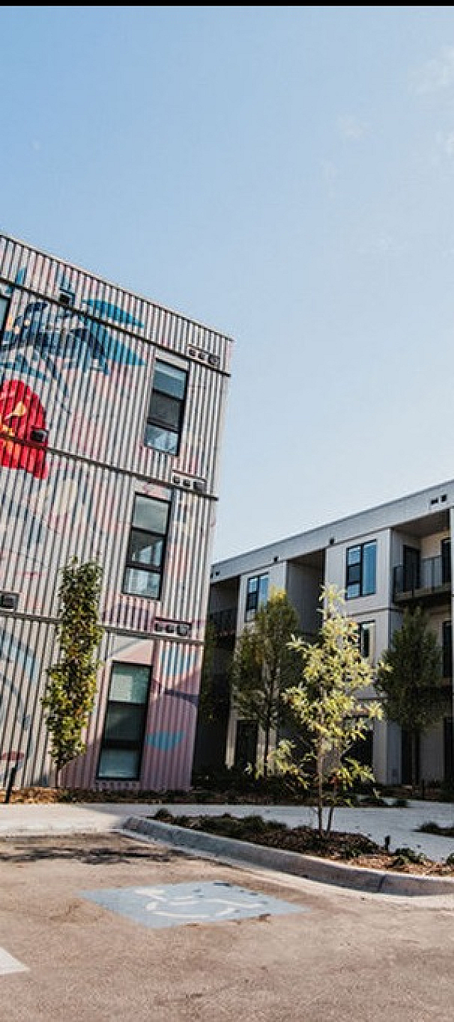 Modern apartment complex featuring captivating artwork on its exterior, offering stylish and unique living spaces at First Street Flats.