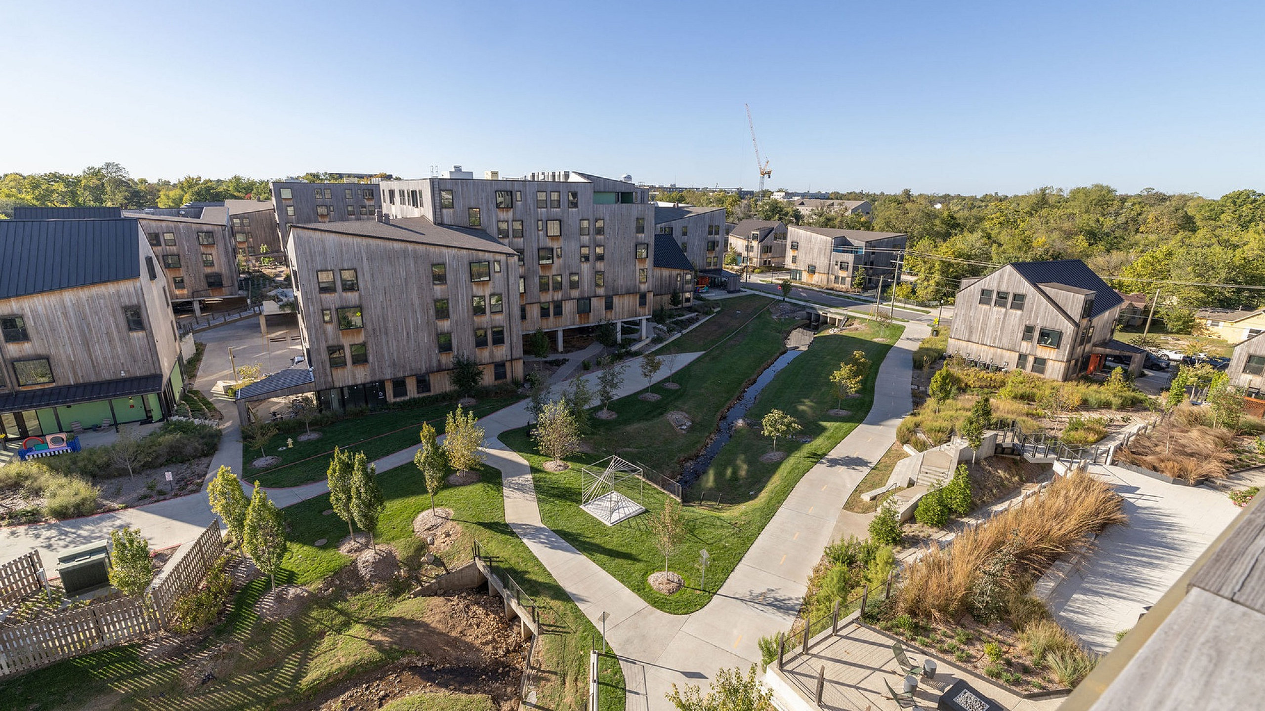 Charming modern apartment complex with greenery, scenic pathways, and contemporary wooden architecture.