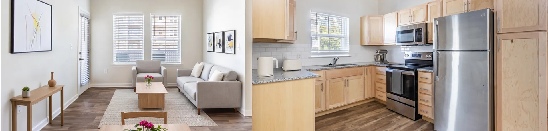 Bright and modern living room with sleek wooden flooring, cozy gray sofa, and elegant artwork alongside a contemporary kitchen featuring stainless steel appliances and spacious wooden cabinets.