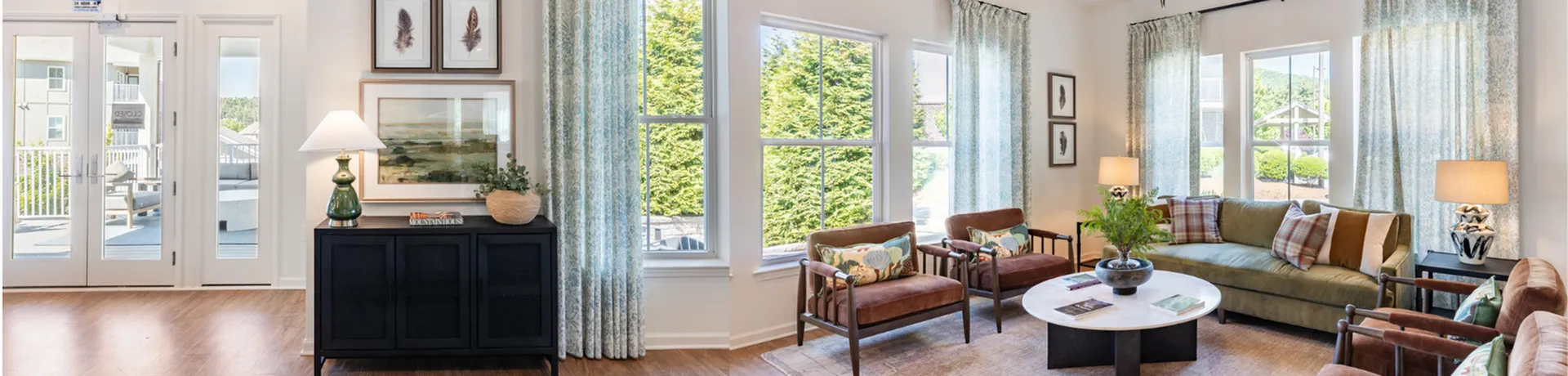 Bright and inviting living room with elegant decor, featuring large windows, modern furniture, and a stylish blend of natural light.