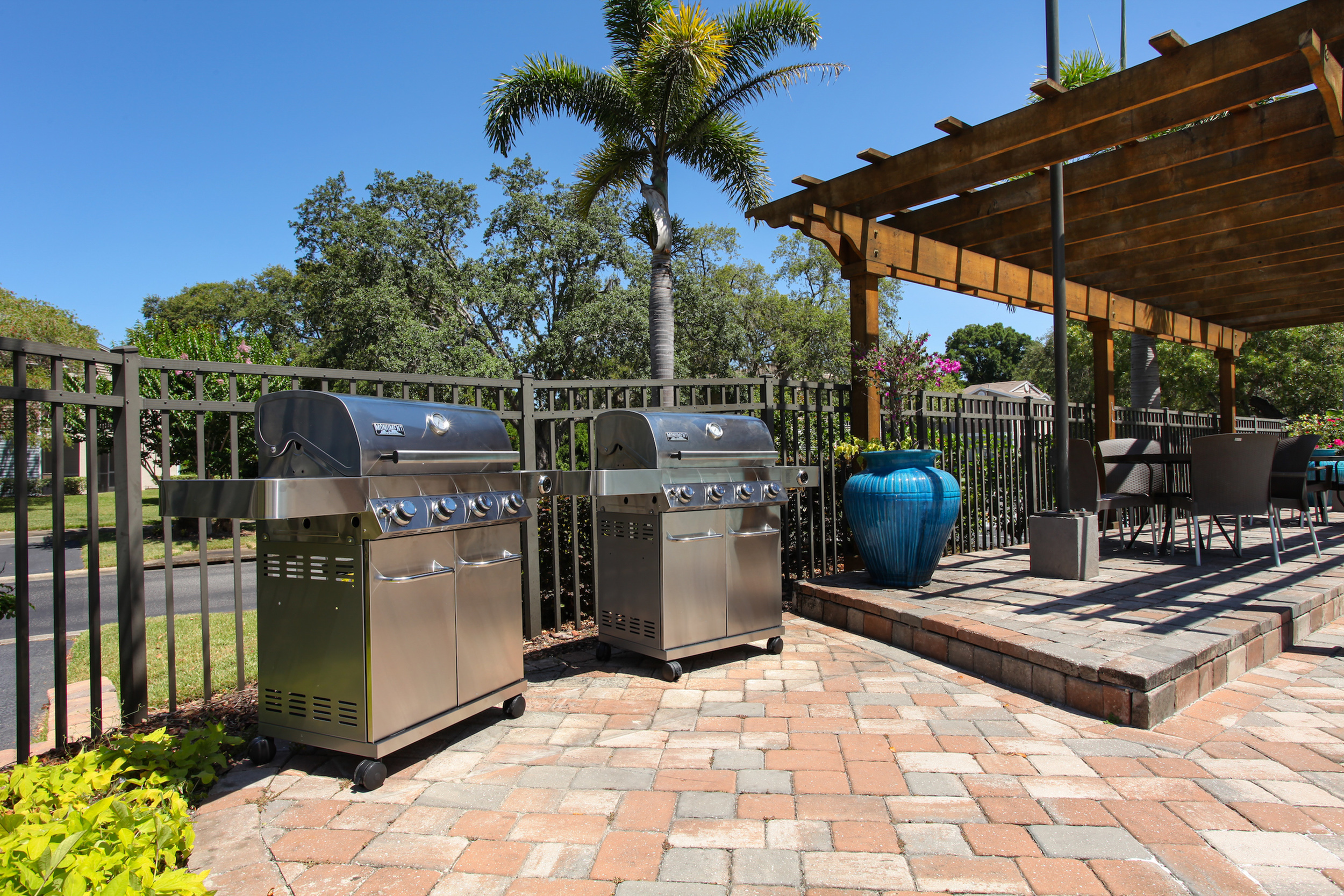 Agora at Port Richey- patio view of grill- nice landscaping- Black fence enclosed around property