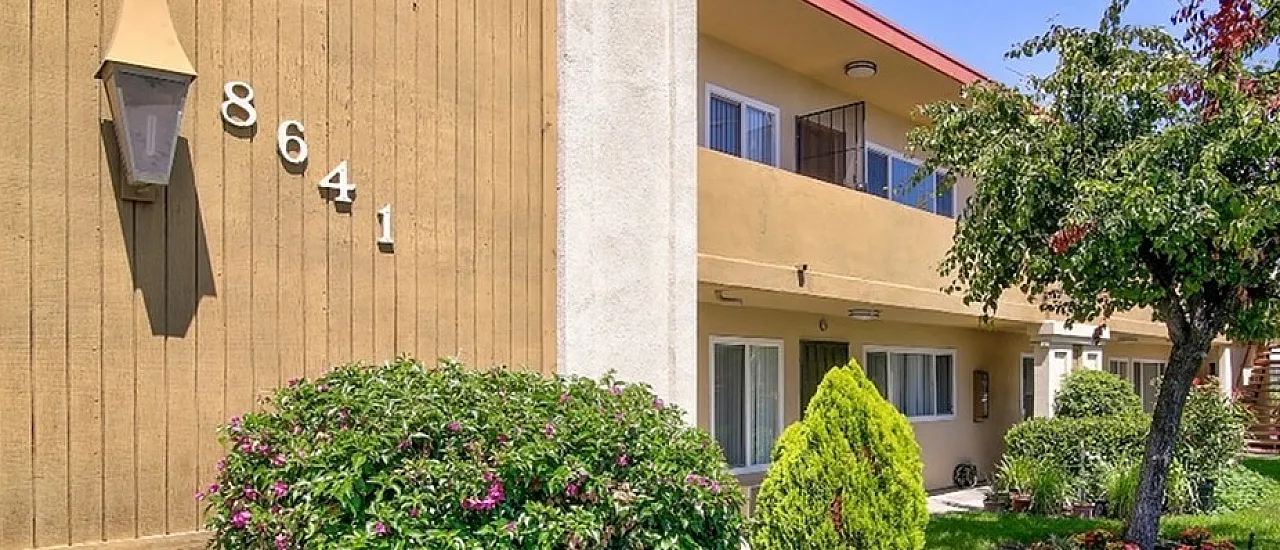 Charming apartment exterior at 8641 with a beautifully manicured garden and inviting facade, perfect for a serene living experience.