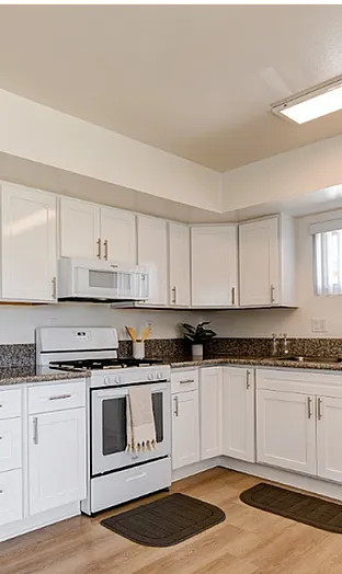 Bright and modern kitchen with sleek white cabinets, granite countertops, and stainless steel appliances, perfect for home chefs.