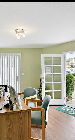 Inviting office space with modern decor, natural light, and a charming garden view through French doors.