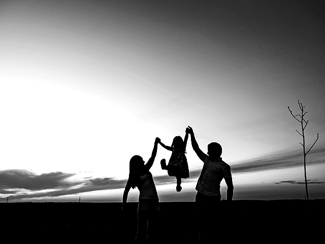 Heartwarming silhouette of a family enjoying a beautiful sunset, evoking feelings of happiness and togetherness.