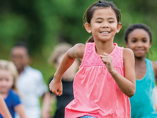 Joyful children running and playing in a lush green park, showcasing active and vibrant childhood fun.