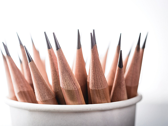 Close-up of sharpened pencils elegantly arranged in a cup, showcasing precision and readiness for creative tasks.