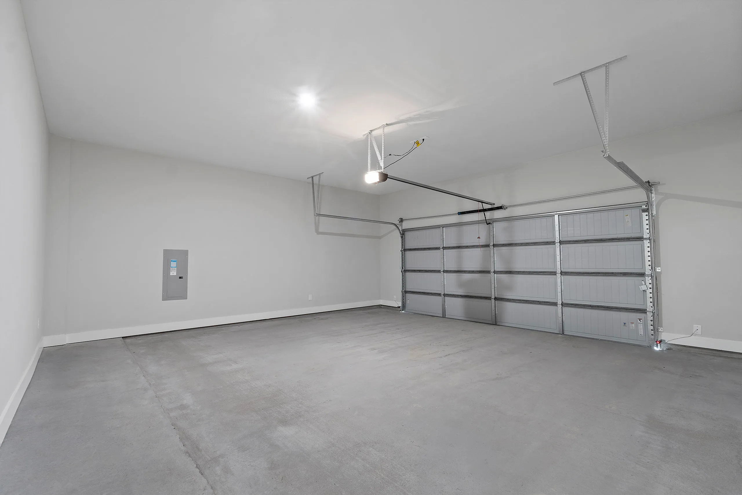 Spacious modern garage with sleek gray floors and an automatic door, perfect for secure parking and storage.
