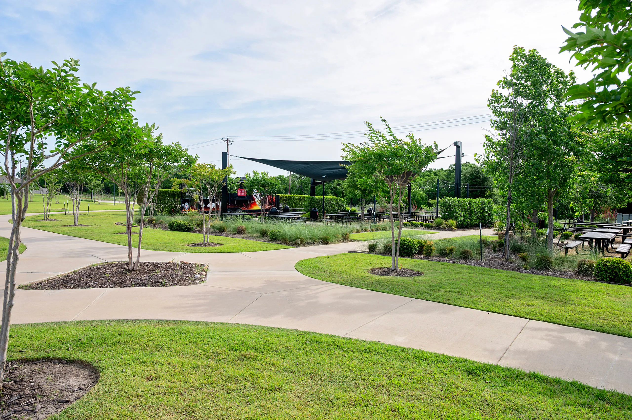 Scenic park area featuring winding pathways, lush greenery, and outdoor seating perfect for relaxation and picnics.