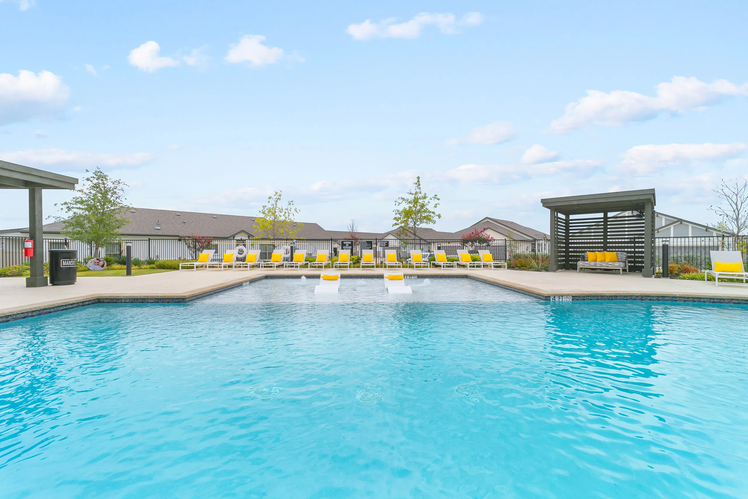 Inviting outdoor pool area with vibrant yellow lounge chairs and a stylish pergola, perfect for relaxation and socializing.