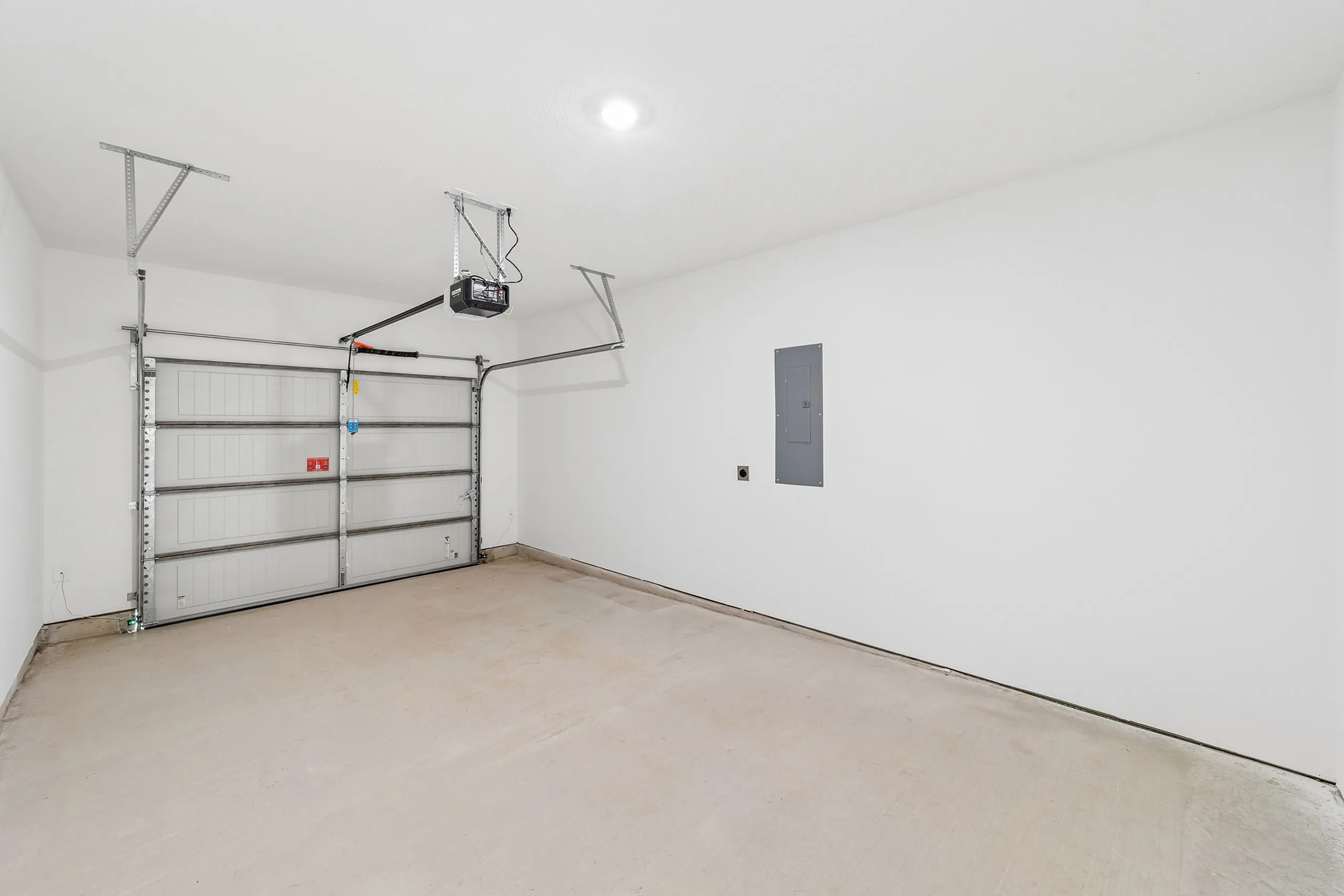 Spacious, well-lit garage with modern garage door and ample storage potential in a sleek apartment.