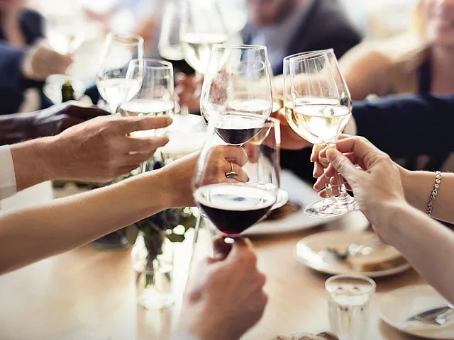 Vibrant gathering with friends raising glasses for a toast, showcasing a lively and welcoming atmosphere.