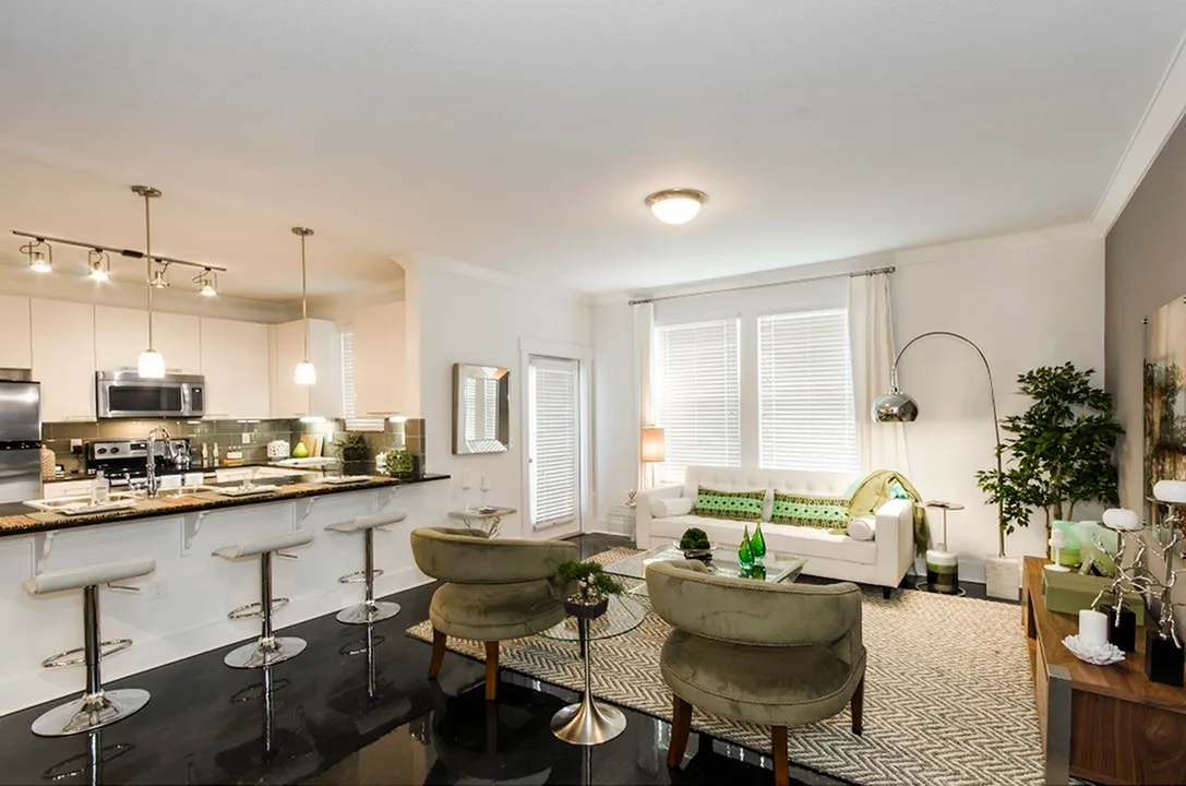 Elegant open living area with modern kitchen, stylish furniture, and ambient lighting.