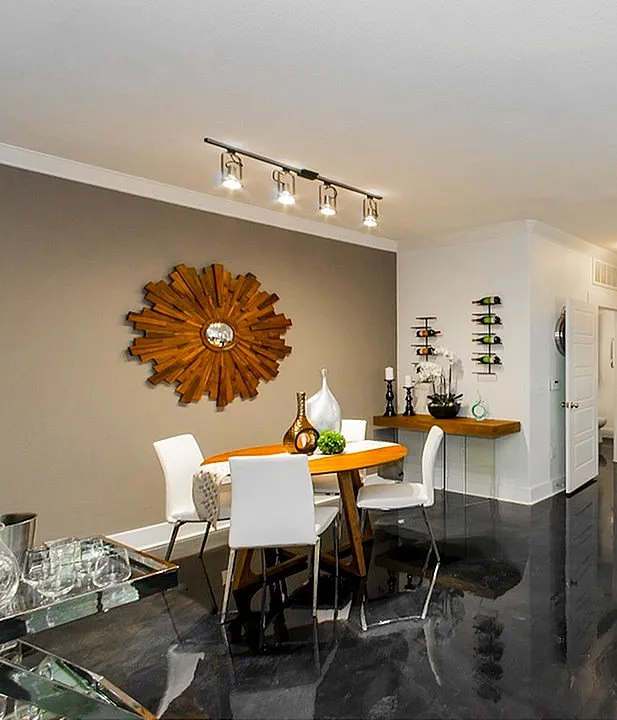Modern open-concept kitchen and dining area with stylish decor, featuring sleek white cabinetry and elegant lighting.