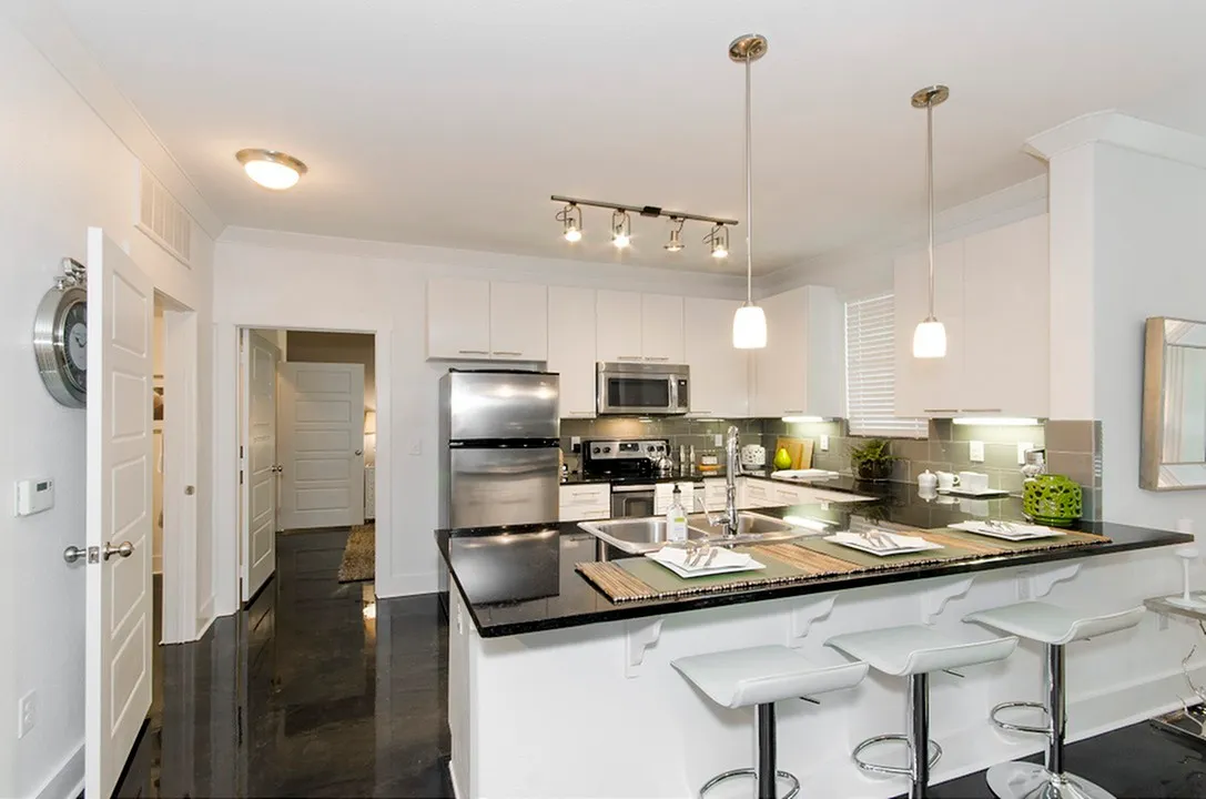 Modern kitchen with sleek countertops, stainless steel appliances, and stylish pendant lighting.