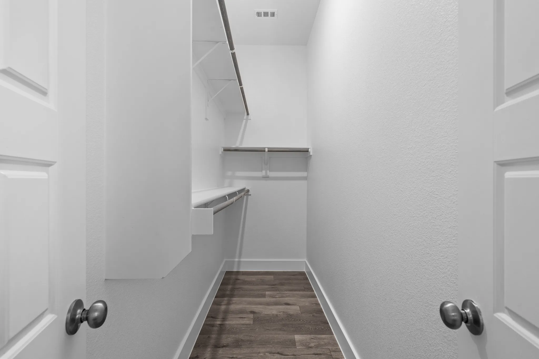 Spacious walk-in closet with elegant shelving and ample hanging space, perfect for stylish storage solutions | Apartments in Hutto, TX | Mansions Eight65