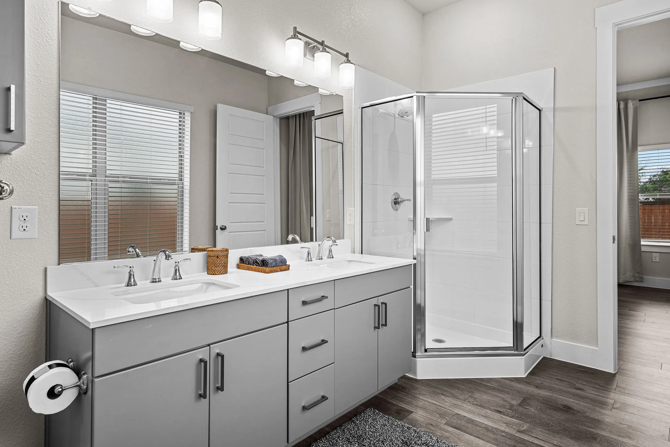 Modern bathroom with elegant fixtures, a spacious double vanity, and a sleek glass-enclosed shower.