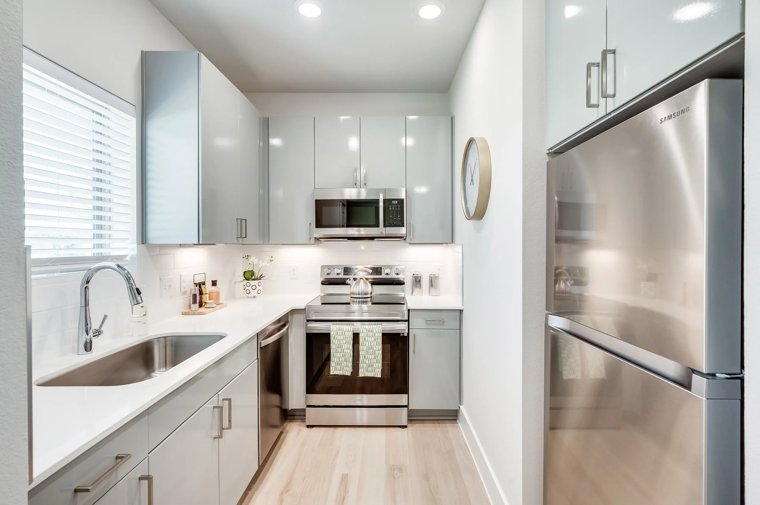 Contemporary kitchen with stainless steel appliances, sleek white cabinetry, and elegant fixtures for modern living.