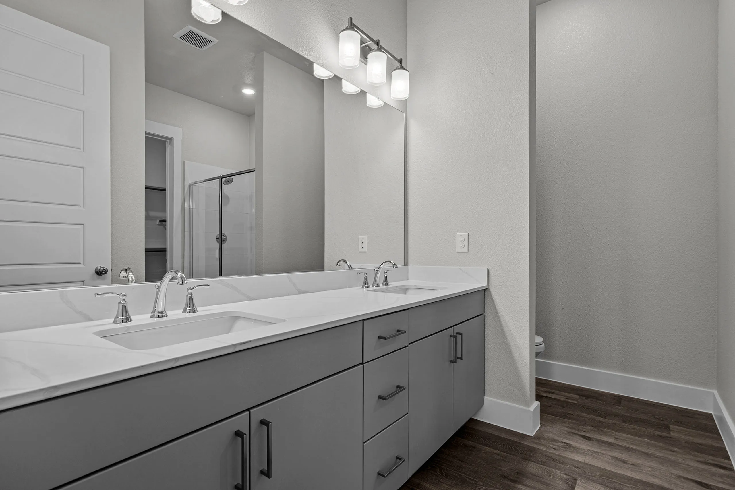 Modern bathroom featuring a sleek double vanity with marble countertop and elegant fixtures.