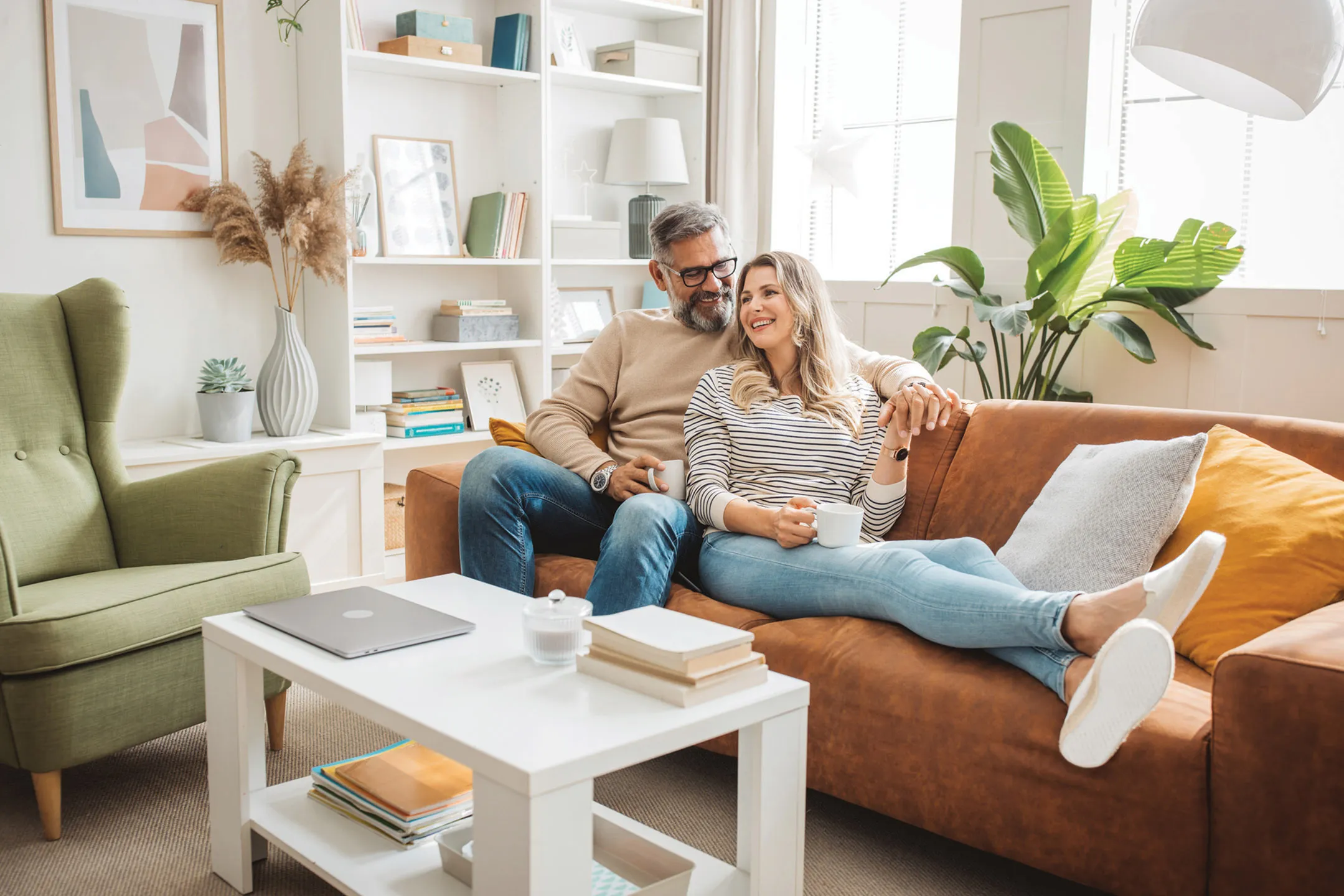 Inviting living room with stylish decor, cozy brown sofa, open bookshelf, and vibrant green plant, perfect for relaxation.